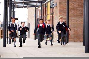 pupils running beside a school building
