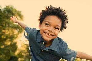 Boy with outstretched arms playing aeroplanes in park