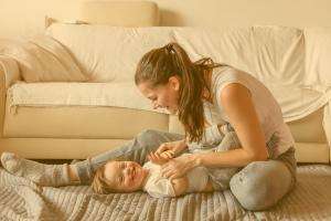 woman playing with young child on the floor