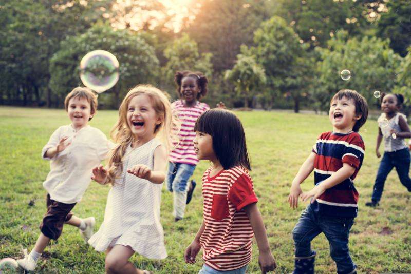 Group of children playing with bubbles in park