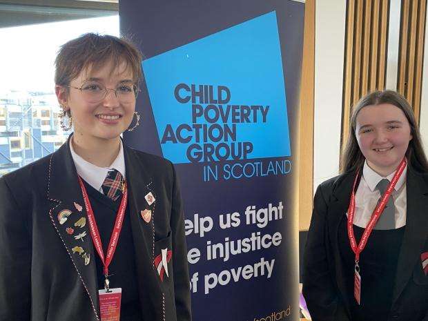 Pupils at a roundtable event, smiling beside a CPAG banner