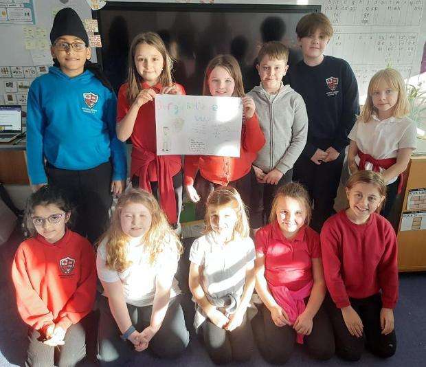 Group of school children in their classroom with poster