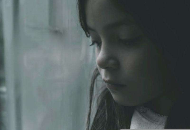 Girl staring sadly out of window