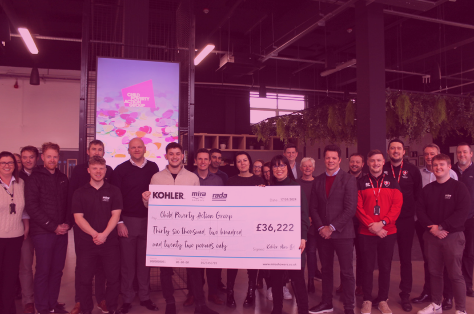 A group of people posing with a novelty cheque for £36,222 made out to Child Poverty Action Group